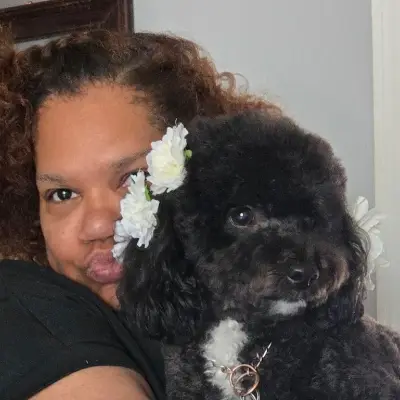 Heather cuddling a black dog